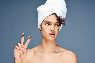 Portrait of shirtless man against blue background