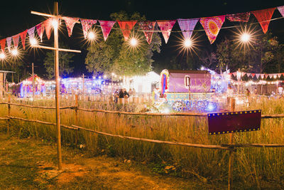 Group of people against illuminated lights at night