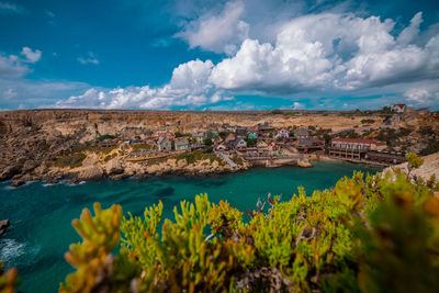 High angle view of townscape by sea against sky