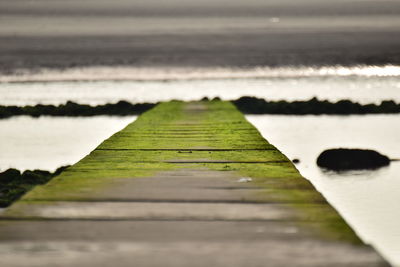 Surface level of wooden walkway against sea