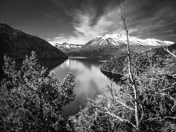 Scenic view of lake by mountains against sky