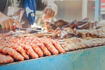 Midsection of butcher selling meat at market