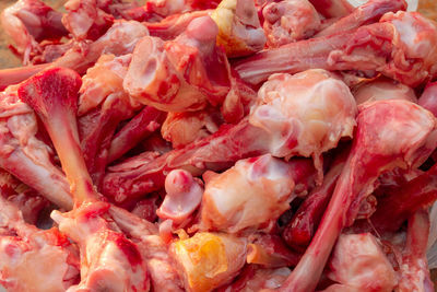 Many raw chopped gnawed chicken bones in heap lie on the table. eating poor people.