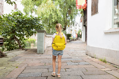 Schoolgirl back to school after summer vacations. happy child smiling early morning outdoor.