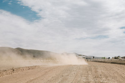 Scenic view of landscape against sky with dust