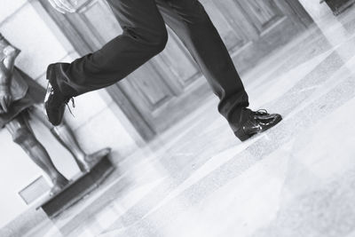 Low section of man walking on tiled floor