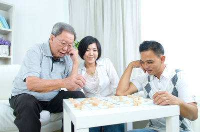 Happy family playing board game at home