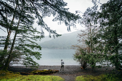 Man standing by lake against mountain