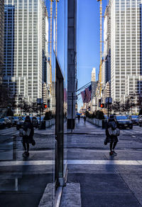 People on street amidst buildings in city