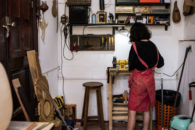 Unrecognized woman in her luthier workshop.