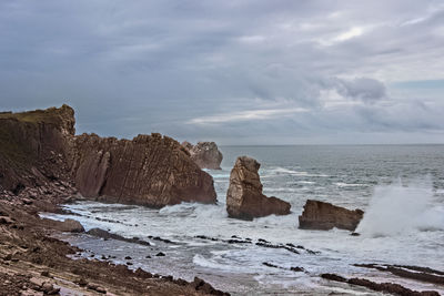 Rocks on beach against sky