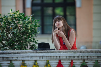 Woman looking away while sitting outdoors