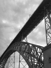 Low angle view of bridge against cloudy sky