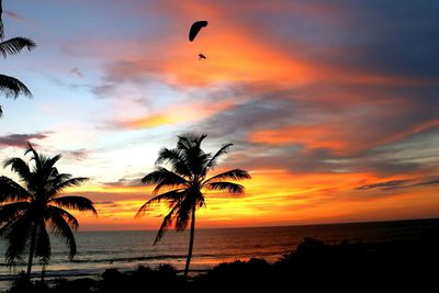 Scenic view of sea against dramatic sky during sunset