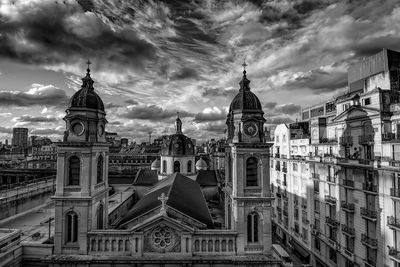 Buildings against cloudy sky