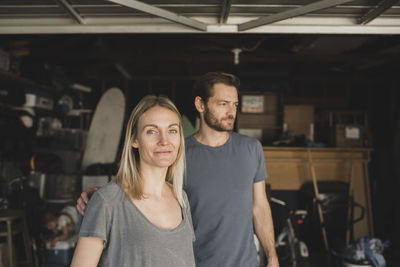 Mid adult parents with daughter in background at storage room of house