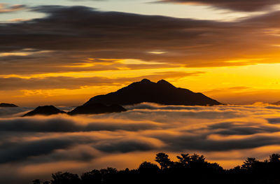 Scenic view of silhouette mountains against orange sky