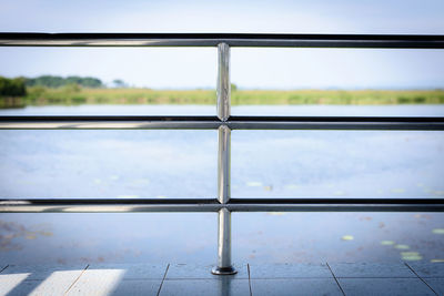 Close-up of railing against sky seen through window