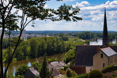 Trees and townscape against sky