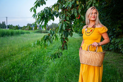 Portrait of young woman standing on field