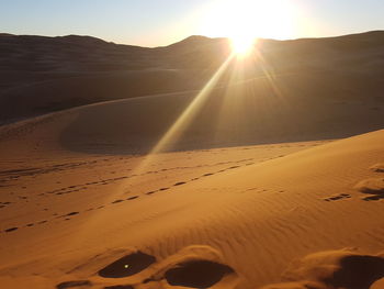 Scenic view of desert against sky during sunset