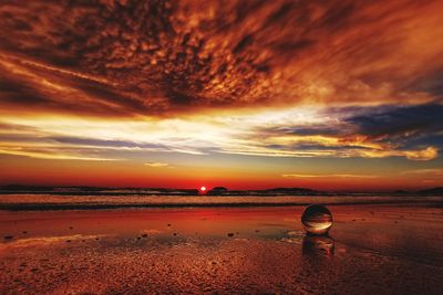 Scenic view of sea against dramatic sky during sunset