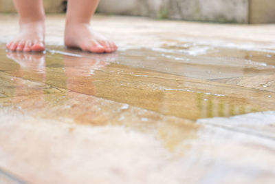 Low section of person standing on wet floor