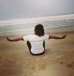 Rear view of woman relaxing on beach