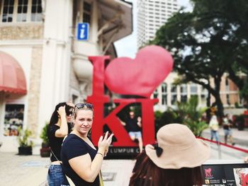 Man photographing with mobile phone in city