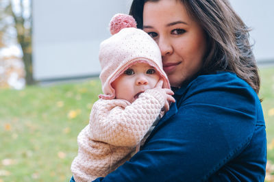 Close-up of mother holding baby in winter