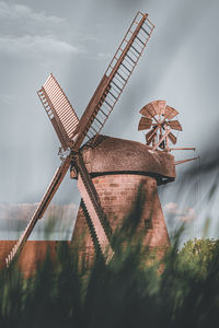 Low angle view of traditional windmill against sky