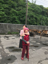 Daughter embracing mother on wet footpath