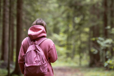 Rear view of woman standing in forest