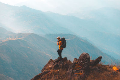 Man standing on rock against mountains