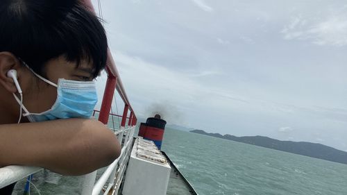 Portrait of boy on sea against sky