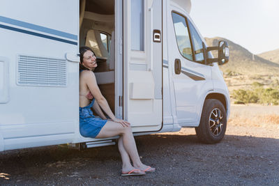 Smiling woman sitting at motor home