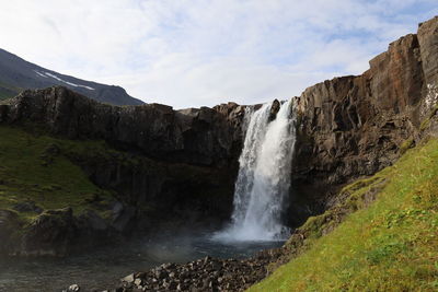 Scenic view of waterfall against sky