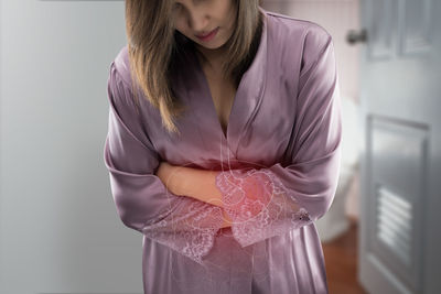 Midsection of woman standing against white background