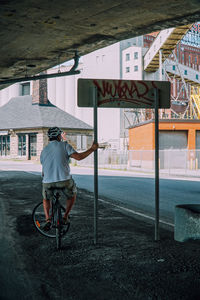 Rear view of man riding bicycle on building