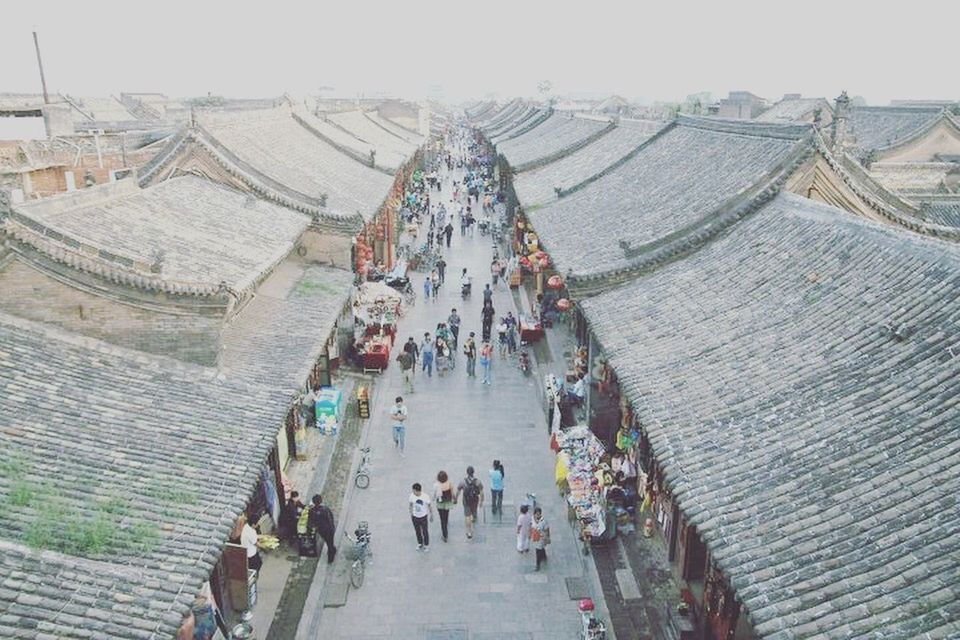 HIGH ANGLE VIEW OF TOURISTS WALKING IN A CITY