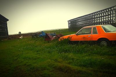 Car on field against clear sky