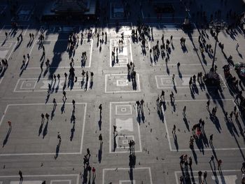 High angle view of people walking on town square in city