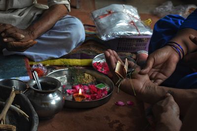 High angle view of people holding religious offerings and paper currency