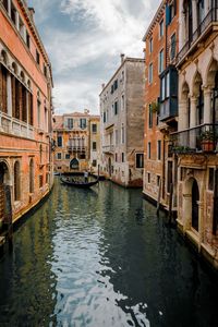 Gondola in canal amidst buildings