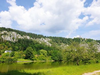 Scenic view of lake by trees against sky