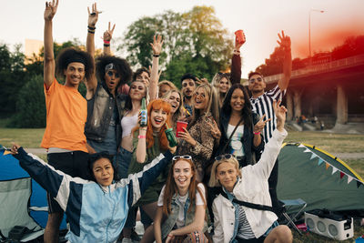 Portrait of cheerful young friends camping during festival