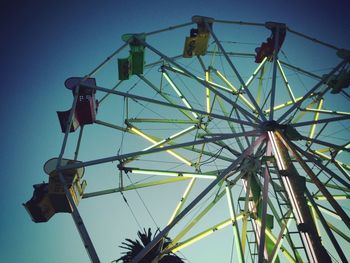 Low angle view of ferris wheel against blue sky