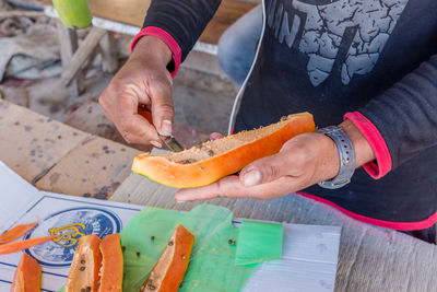 High angle view of man cutting papaya