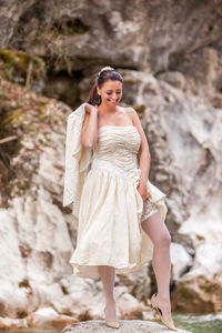 Portrait of young woman standing on rock