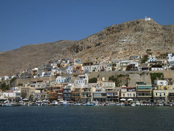 Town by sea against clear blue sky